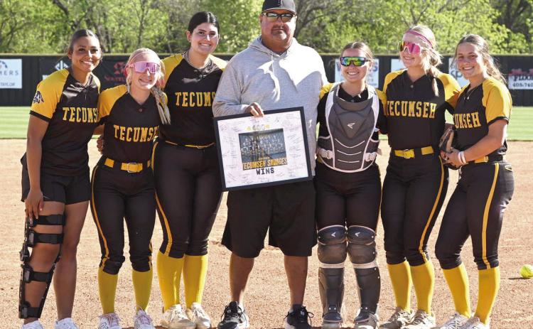 Before the April 7 home game against McLoud, Coach Perry Wilson was presented with a signed, framed photo commemorating his achievement of 400 coaching wins. Wilson is shown here with Tecumseh seniors, from left, Khabrei Simpson, Blakelee Parker, Tylee Brock, Maggie Wilson, Steeli Mitchell and Cadence Leba. Photo courtesy of Kenetta Lisenbee