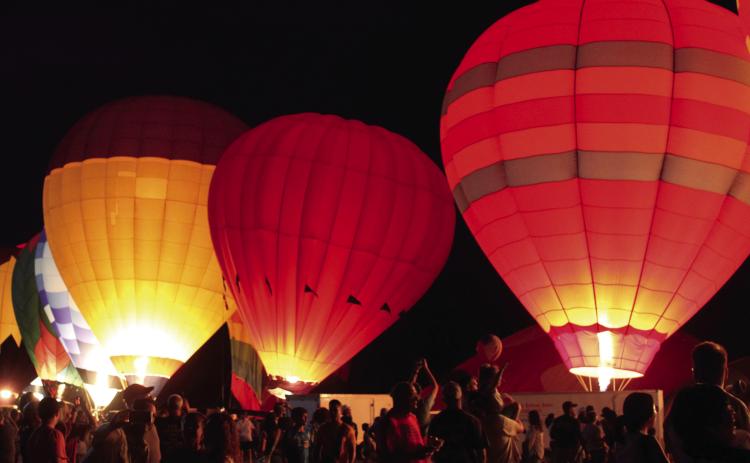 Hot-air balloons light up during the Balloon Glow on Friday, Aug. 9, at the FireLake Fireflight Balloon Festival. There were 25 balloons at the event this year, mostly from Oklahoma and the surrounding states. They also offered tethered rides and early morning balloon launches. File photo