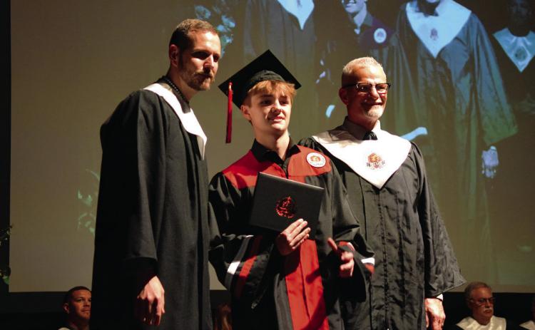 Bronson Armitage receives his diploma from Principals Justin MacDonald and Chad Brooking. Photos by Julie Talton, Countywide & Sun
