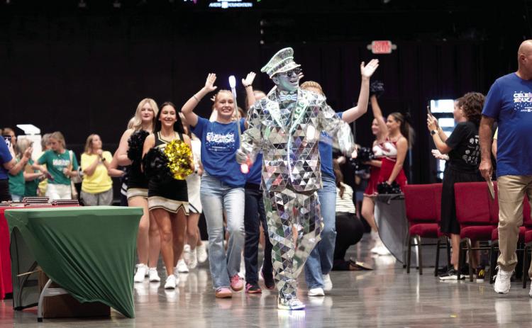 Entertainer “The Mirror Man” leads a processional of area students and a drum line into the Firelake Arena. Photo courtesy of Jesse Monday