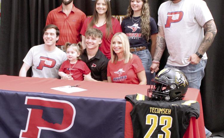 Tecumseh senior Zant Shirey signed a letter of intent for football with Oklahoma Panhandle State University in Goodwell on March 11. Shown, seated from left, are brother Ethan Shirey, Wren Shirey, Shirey, mother Misty Shirey, back row, Garrett Degelos, sister Dacee Degelos, Kyann Sells and Kyle Goodin. Natasha Dunagan, Countywide & Sun
