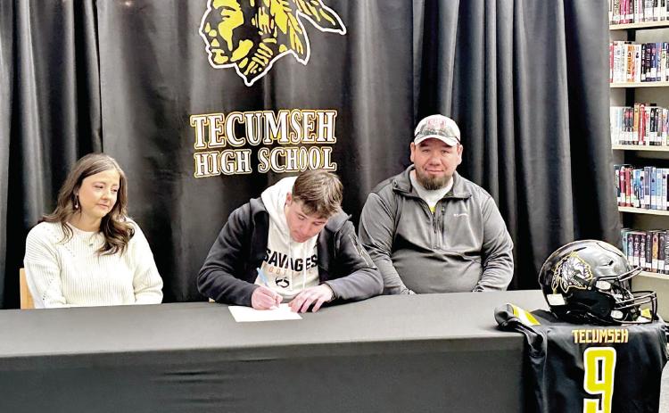 Tecumseh's Kaseon Pines signs a letter of intent to play football with Panhandle State University on Feb. 13, as his parents Tiffany and Jake Pines look on. Photo provided by Casi Bays.