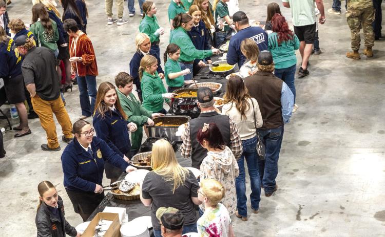 Attendees line up for the traditional PCJLS Trophy Auction dinner, served by 4-H and FFA members. Approximately 575 meals were served before the record breaking auction began. Photo provided
