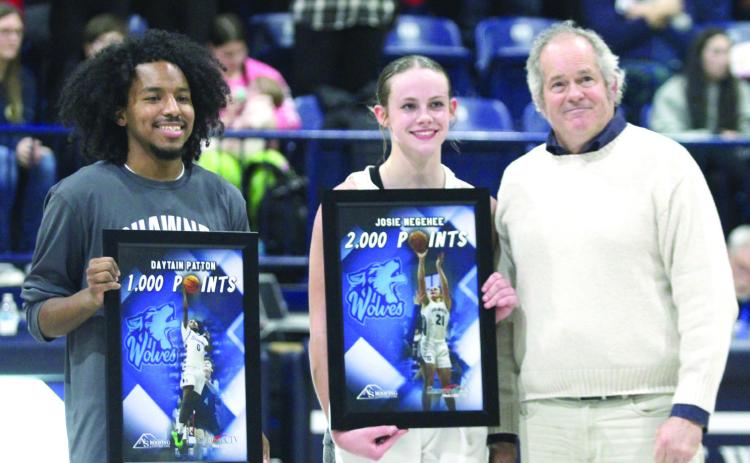 Daniel Shaughnessy, with Shawnee CTV, presents framed pictures to Shawnee seniors Daytain Patton, who has reached 1000 points, and Josie Megehee, who has made 2,000 career points, between games on Feb. 8. Both also received basketballs from the games where they reached their milestones. Countywide & Sun/Natasha Dunagan