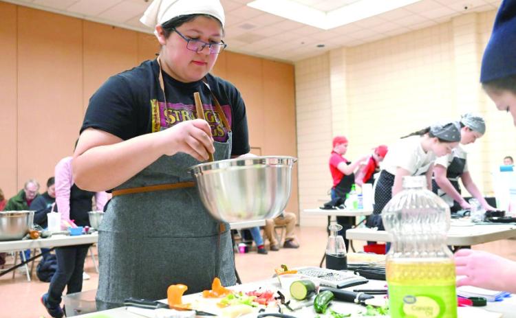 Ciara Vance from Scissortail 4-H is mixing ingredients. Photo provided