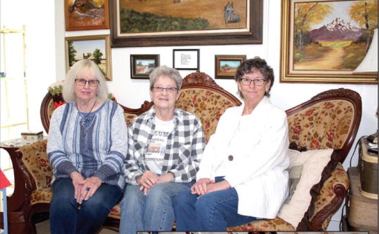 Tecumseh Historical Society Board Officers Arthenia Haney, Jane Fleming and Jan Parker pose on the Carters' Victorian couch at the Tecumseh museum. They and others have put in many hours of work on the museum buildings and curating donations, and they hope that more people will volunteer. Countywide & Sun/Natasha Dunagan