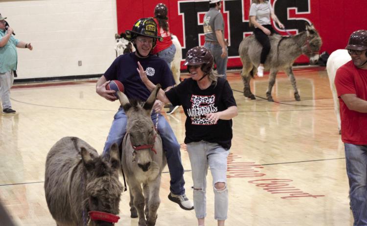 Earlsboro teacher Lisa Coomer tries to steal the ball from fire fighter Cal Locke, while off her donkey, during the Donkey Basketball game at Earlsboro High School on April 9. The Town of Earlsboro fund-raiser featured two games: Earlsboro Police and Fire Departments vs. Earlsboro Teachers and the Mize Agency vs. Earlsboro students. They also raised money through a dessert drawing, silent auction and a pre-game dinner.