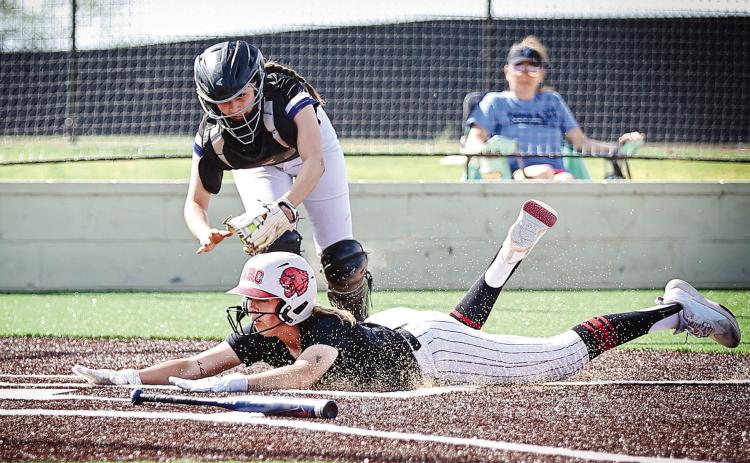 NRC's Sophie Morris slides past the Little Axe catcher for the score. North Rock Creek won both games on their new turf field, March 30, against Little Axe and Lexington. Photos Courtesy of Gowin Photography.