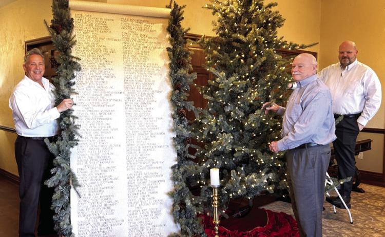 J. Cooper, Gary Schutten, and Landon Qualls pose with the Scroll of Honor and the Christmas Tree of Remembrance at Cooper's Funeral Home in Tecumseh. Cooper's will present “A Christmas Keepsake” program in the chapel for the 34th year on Sunday, Dec. 7 at 2 pm. The families of those served by Cooper's this year are invited to attend. Suzie Campbell, Countywide & Sun