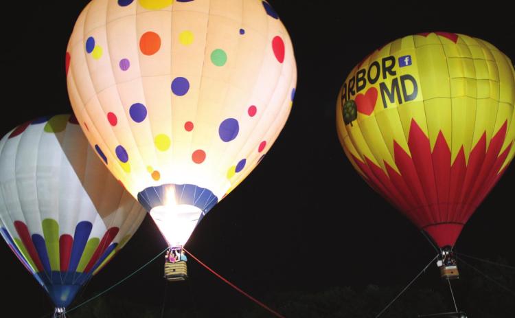 A polka dot hot-air balloon illuminates its two nearby balloons during the Balloon Glow of the FireLake Fireflight Balloon Festival on Aug. 14. Countywide &amp; Sun/Natasha Dunagan