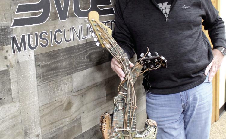 Music Unlimited Owner Jeff Hawkins poses with his favorite guitar artpiece at the store in Jan. 2025. Hawkins passed away in March 2025, but his wife, Joni Hawkins, is keeping his dream alive and the business running. Singer-Songwriter Night, which was started by Jeff and his friend Kevin Hall, resumed last September. File Photo