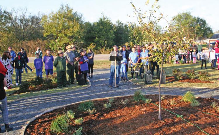 Macomb Public School Superintendent Matthew Riggs (center) speaks at the Reflection Garden dedication, Oct. 28. The tree pictured is at the center of the garden and is a sappling from the Survivor Tree at the Oklahoma City National Memorial. Countywide &amp; Sun/Kendra Johnson