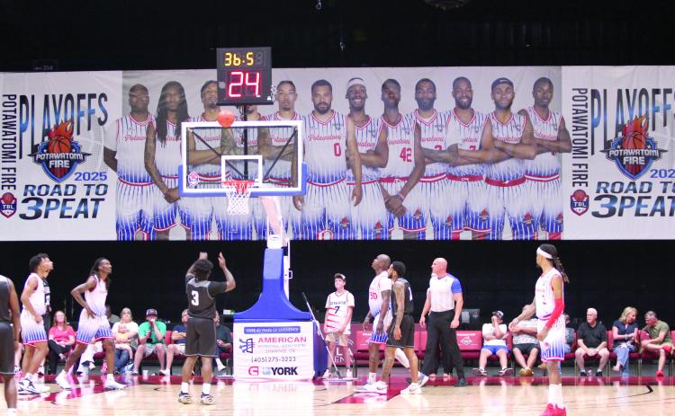 An Enid player shoots free-throws with a giant Potawatomi Fire 'Road to 3Peat' banner as a backdrop during the first quarter of the Central Division Finals Game 2. The Fire beat the Enid Outlaws, 157-89, in this game and in the first game at Enid, 122-98. They move on to the Midwest Conference Finals today (June 5) and June 7, both days at 7 pm at FireLake Arena, according to potawatomifire.com.