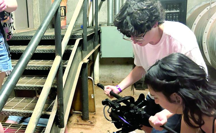 NIcholas Kosemund is shown here using a boom mic to slide his cinema camera in this action shot for his Oklahoma Art Institute film short over the summer. Photo Provided.