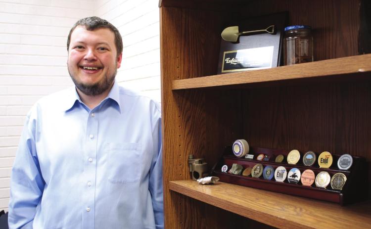 Shawnee Assistant City Manager Jacob Foos stands in his office by a shelf of mementos from other cities where he’s worked. Foos moved to Shawnee and started his current job in Sept. 2021. Countywide &amp; Sun/Natasha Dunagan