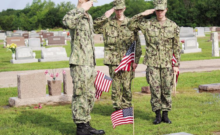Petty Officer Third Class Lukasz Baker, Seaman Recruit Kenneth Irwin, and Chief Petty Officer Anna O’Dell salute a flag placed on a veteran’s grave at Tecumseh Cemetery on May 20. There are approximately 1,200 veterans’ graves at the cemetery, which were decorated in preparation for Memorial Day by the U.S. Naval Sea Cadets and Training Ship Oklahoma members, according to Sea Cadets Regional Director Donna Snodgrass. Countywide &amp; Sun/Natasha Dunagan