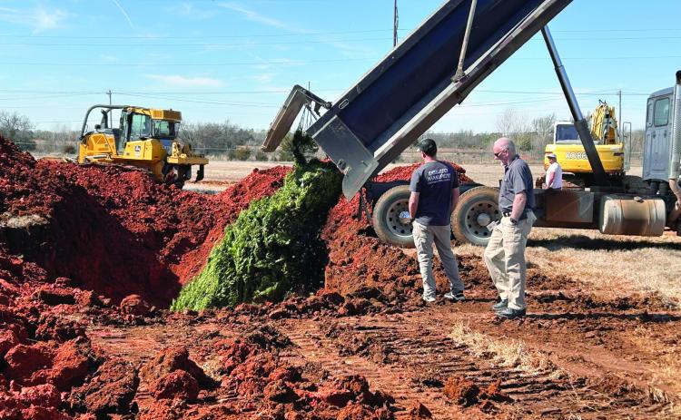 Pottawatomie County Emergency Management Director Chad Larman and volunteer Kurt Shultz watch as the first truck dumps it’s load of marijuana plants into the freshly dug hole. Countywide &amp; Sun/Suzie Campbell