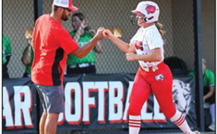 North Rock Creek Coach Griffin gives a fist bump congratulations to Molly Campbell as she rounds third base on her home run hit.