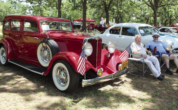 Louis Hopper and his son, Rod Hopper, both of Tecumseh, sit between their rare cars during the 39th Annual Knights Auto Club Car Show at Boy Scout Park on July 27. L. Hopper bought the white 1952 Henry J in 1982, and R. Hopper, who was 15 then, helped to restore it. The red 1932 Hupmobile was purchased by L. Hopper in 1987, and he searched for parts and worked on it for 16 years before he was finally able to drive it.  See full caption below results.