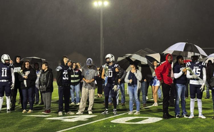 Football players and their families participate in the Shawnee High School Fall Senior Night - a very rainy night - on Nov. 8. Band, cheer, choir and cross country seniors were also included. Photo provided by Amanda Johnson