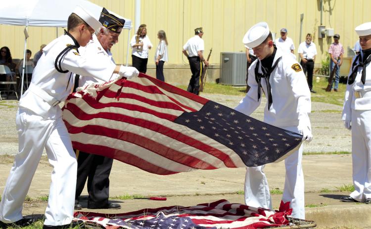 American Legion Post #260 Commander Tom Snodgrass supervises as U.S. Naval Sea Cadets Aaron Shattuck and Joeby Komppa place flags on a grate to be retired by fire during the Flag Day Celebration and Flag Retirement in Tecumseh, June 15. Countywide & Sun/Natasha Dunagan