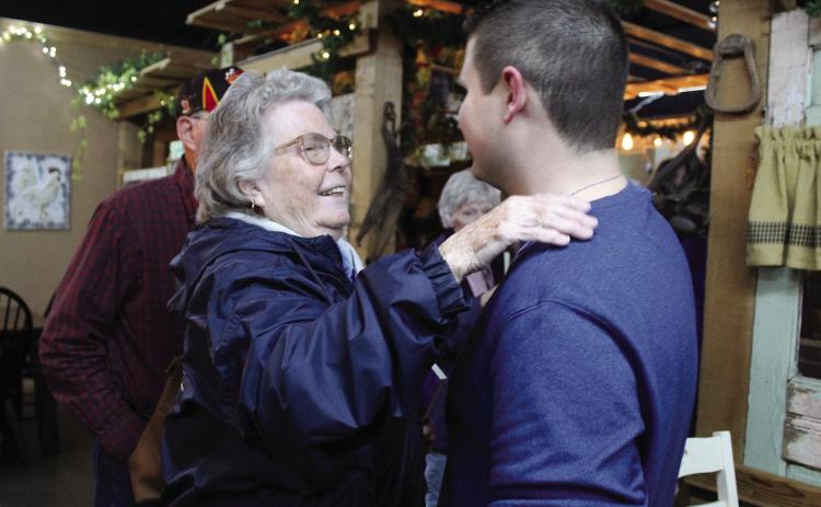 Tecumseh author Joey Perry, right, is congratulated by his great aunt Rebecca Anson, of Seminole, during the launch of his memoir at The Farmer’s Daughter Market on Dec. 2. Perry sold out of all 60 copies of his book, “I Have a Reason: An Autistic Perspective on Bullying.” Countywide &amp; Sun/Natasha Dunagan