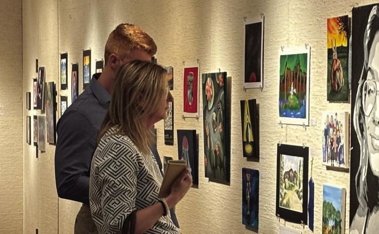 Visitors looking at the High School Juried Art Exhibit during the opening reception. Photo provided by Mabee-Gerrer Museum of Art