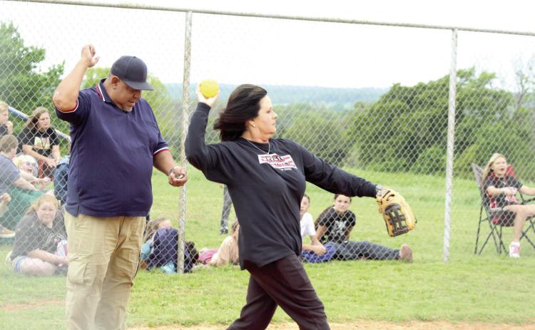 Macomb Fellowship of Christian Athletes leader Helen Lee tosses the ball to the pitcher in her role as catcher during the Macomb Staff vs. Players Game on April 29. Also shown is umpire Eric Thlocco, who was honored during the game for serving as an umpire for 30 years and planning to retire. See more about Thlocco in a future issue of the Countywide & Sun.