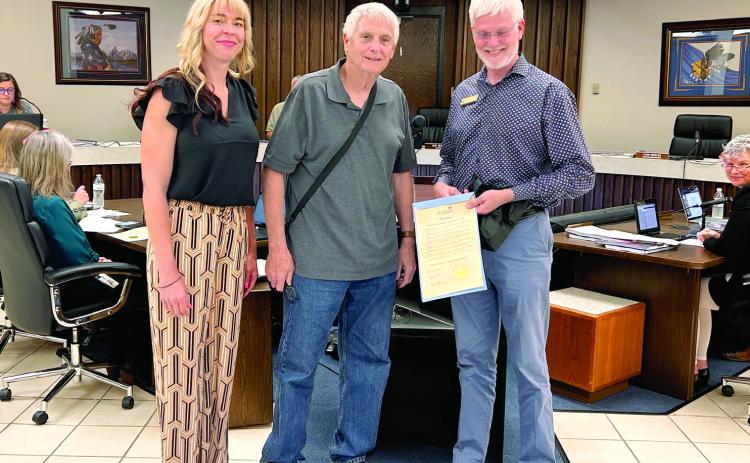 Mayor Ed Bolt Proclaimed the month of May 2024, Better Speech, Hearing, and Language Month. Doctors of Audiology Calyn Russ-White (left), and Kurt Kalies (right) receive the proclamation. Afterwards, Dr. Kalies hands out ear plugs to the those attending the meeting. Countywide &amp; Sun/Suzie Campbell