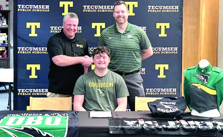 Tecumseh's David Lawrence signed with Oklahoma Baptist University Bison Brigade Band. Shown shaking hands are Tecumseh Band Director John Outon, left, and OBU Band Director Dr. Brian Stackhouse. Photo provided by THS