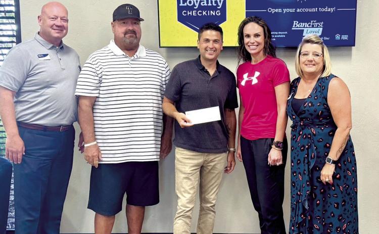 BancFirst presents Tecumseh Athletics with a $1,000 check to assist in the purchase of the 5A Slow Pitch State Championship rings. Pictured from left: BancFirst President &amp; Regional Executive Casey Bell, Coach Perry Wilson, Justin Wood, Director of Community Engagement, Casi Bays, Athletic Director, and Kellie Clay Vice President, BancFirst. Photo provided