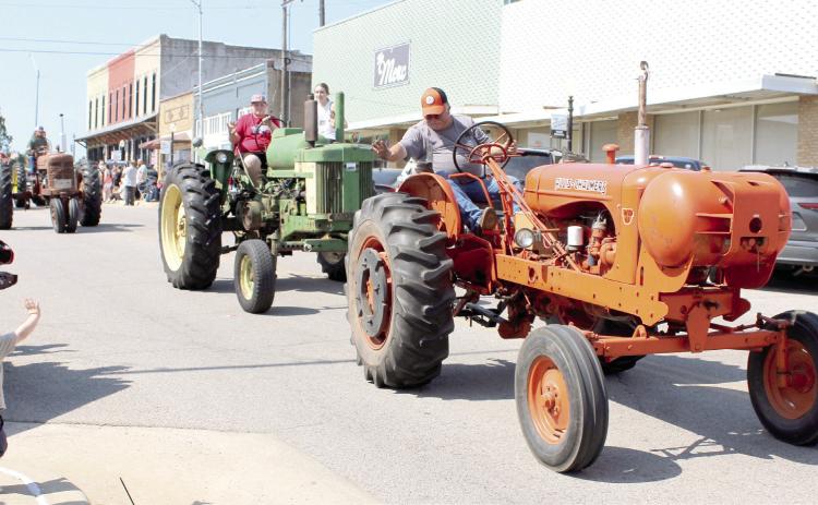 A member of the Shawnee Tractor Club waves to a young boy during the McLoud Blackberry Festival Parade on July 13, 2024. There were 75 entries in the parade. File photo